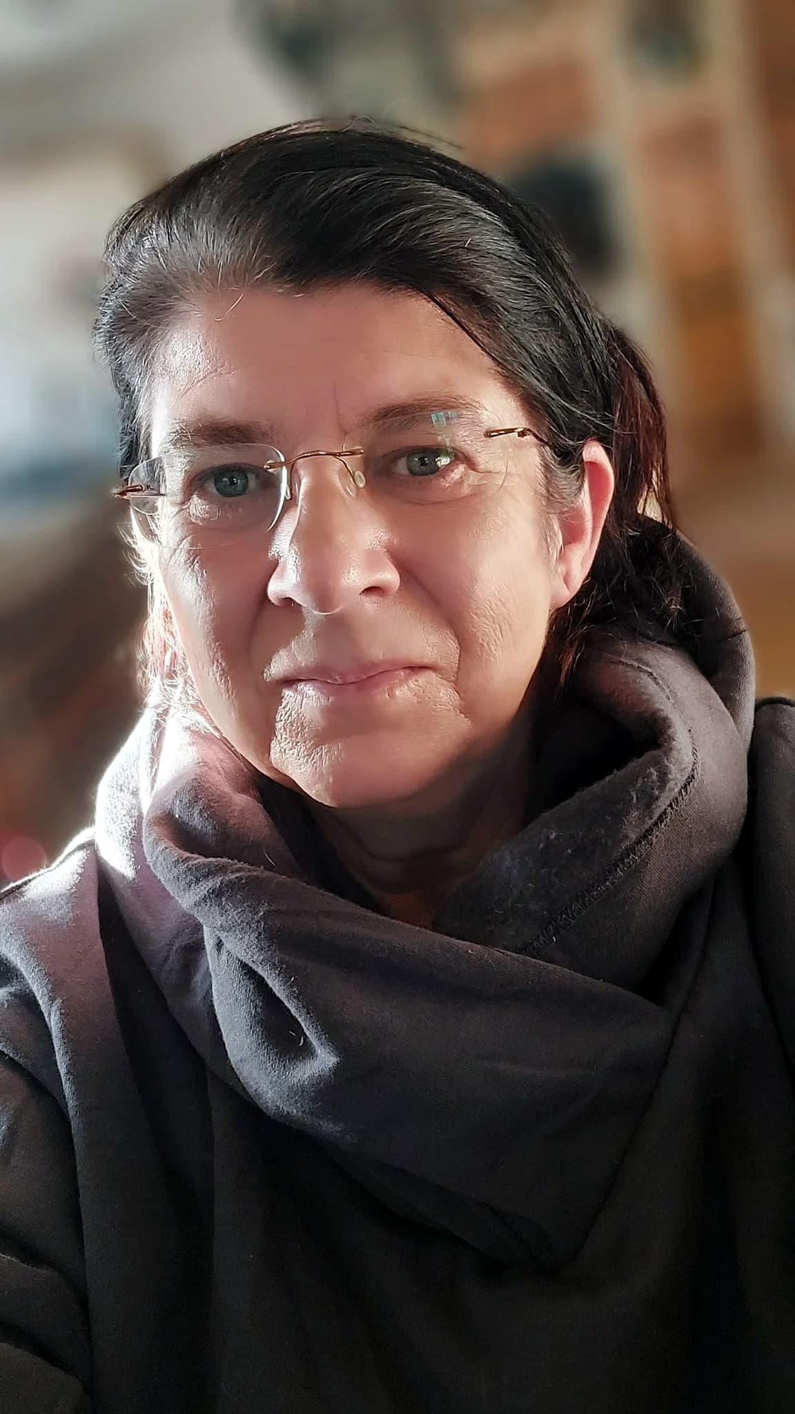Eva Barwig mit ruhigem Blick und dunklem Schal, in einem Innenraum